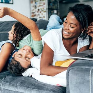 Mother and children playing on couch