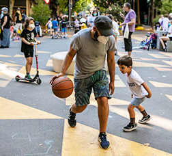 Home i nen jugant a bàsquet a la via pública