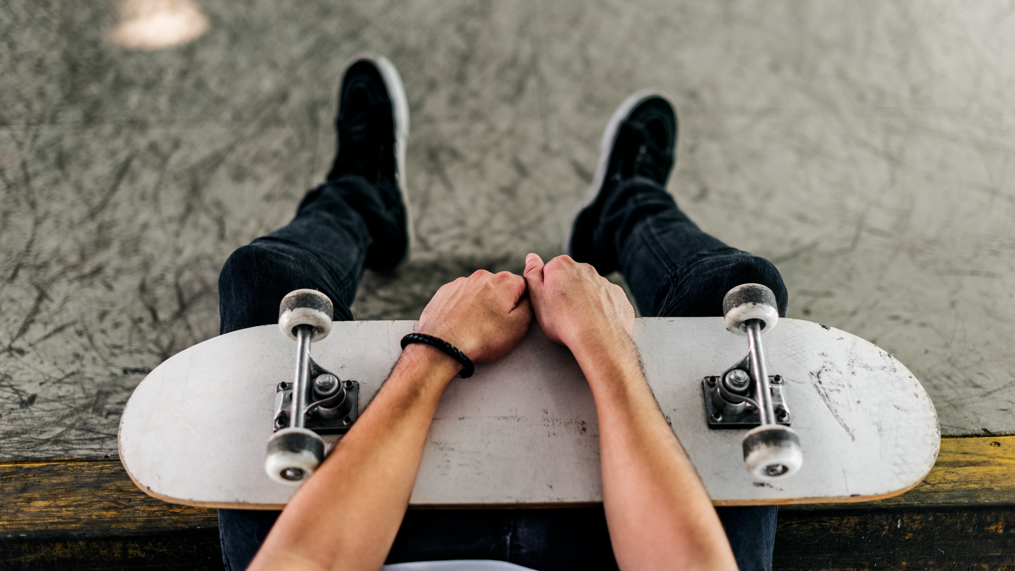 young man with a plain but well used skateboard