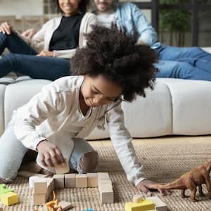 Girl playing with toys in family room.