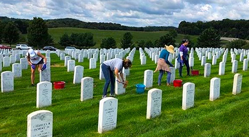 Headstone cleaning at a VA national cemetery to preserve a Veteran's legacy on the National Day of Service.