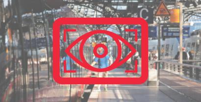 Ein Logo mit einem wachenden Auge, dahinter ein Bahnhof.