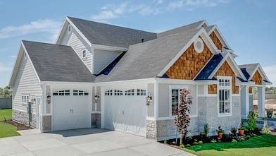 Garage view of home with shingle roof