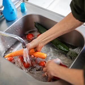 A woman washing vegetables in the sink