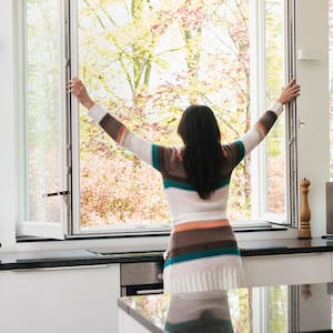 woman opening windows in kitchen