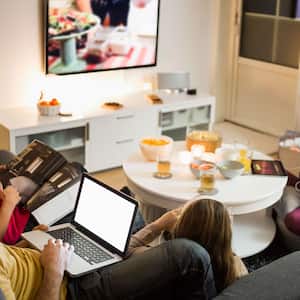 Family watches TV and play on electronics