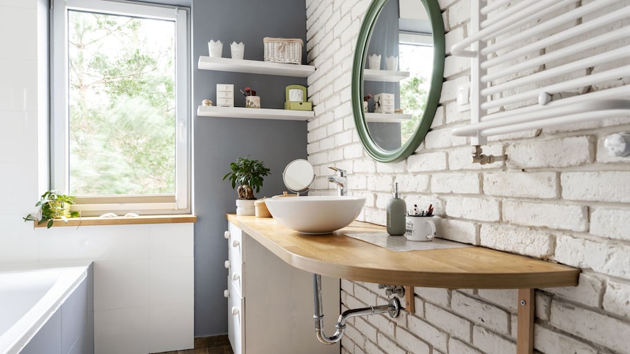 A bright bathroom with exposed brick wall