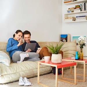 Couple sitting on the sofa using tablet for a video conference