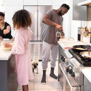  Father and daughters making breakfast in their pajamas