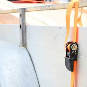 An orange ratchet strap on a trailer for safely moving stuff