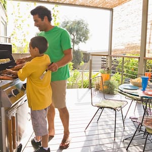 Father and son barbecue on deck