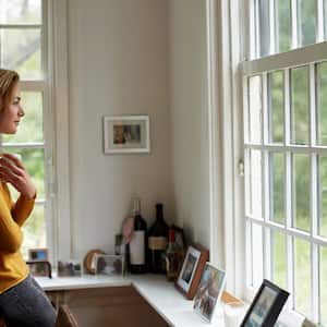 Woman with coffee cup looking out a window