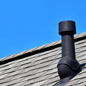 Black air ventilation chimney on gray shingles
