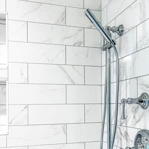 A modern shower with white tiles