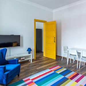 Living room with yellow door and blue sofa
