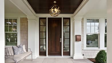 Dark wood front door under front porch