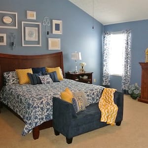 A bedroom decorated in French Country style with blue and yellow accents. 