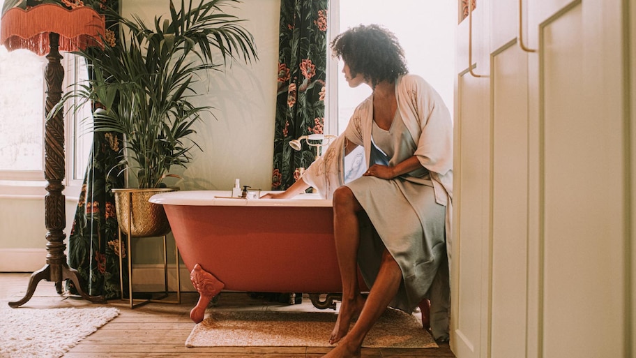 Woman next to a bathtub in a luxurious room