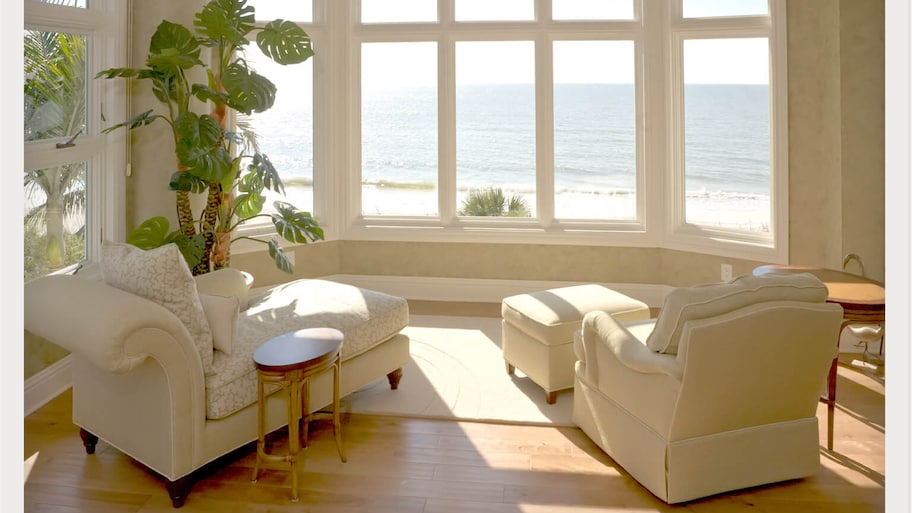 sunroom with chairs and windows with waterfront views