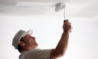 Tradesman painting a ceiling