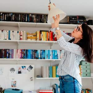 A woman changing a light bulb 