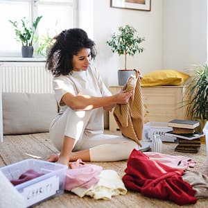 Young woman sorting her wardrobe clothes