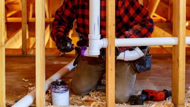 plumber installs pipes in a home