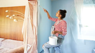 A pregnant woman painting a room