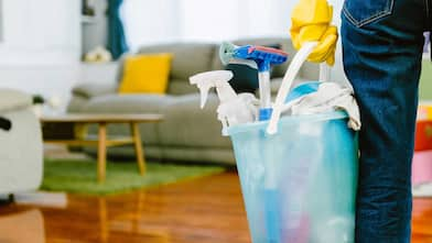 Person carrying bucket of cleaning supplies