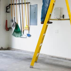 A man standing on a ladder inside his home’s garage