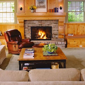 A living room with a fireplace located in the basement of a house