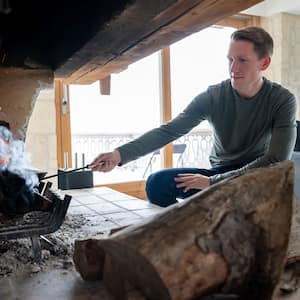 Man burning logs in the fireplace