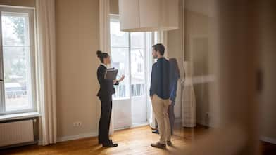 A realtor showing a house to a young couple