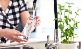 woman filling water bottle from tap