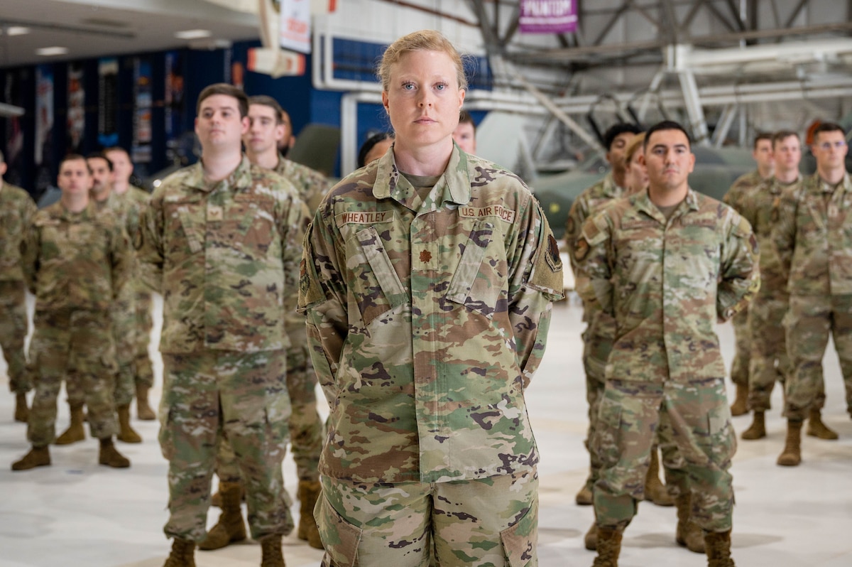 Military members stand in formation in a diagonal shape