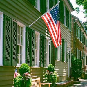 A row of green townhouses with exterior shutters