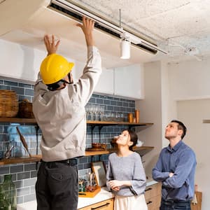 An inspector checking the AC unit in the kitchen