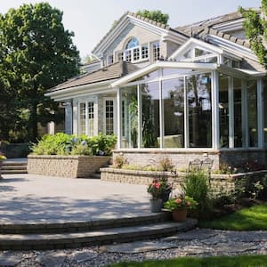 The exterior of a house with a sun room and a lush garden