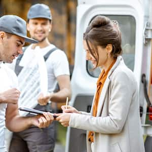 A homeowner signing a contract with a moving company