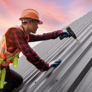 Roofer installing metal sheet roof
