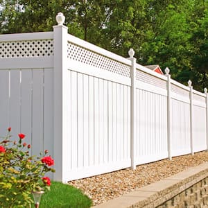 White vinyl fence in backyard with nice landscaping in the foreground and background