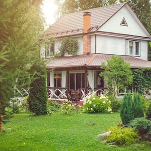 The exterior of a country house with green backyard