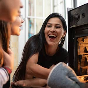 Friends cooking dinner in the oven