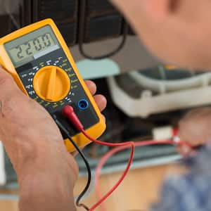 Man reading multimeter at home