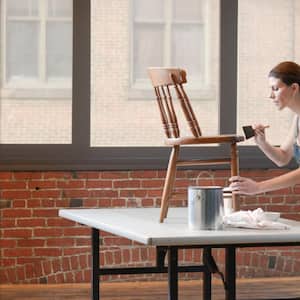 Woman painting chair in loft