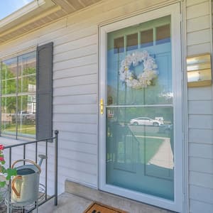 House with glass storm door covering green front door