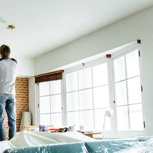 A man paints a ceiling