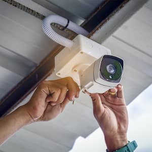 Person installing exterior home security camera