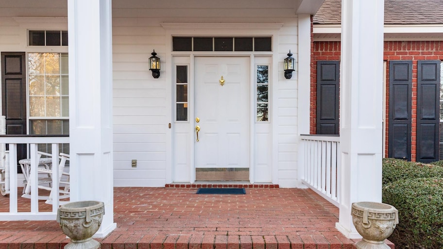 A porch with a white front door