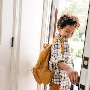 A young boy closing the door behind him